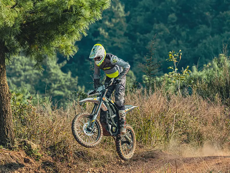 Ein Fahrer mit einer Sur-Ron Ultra Bee beim Sprung im Gelände.