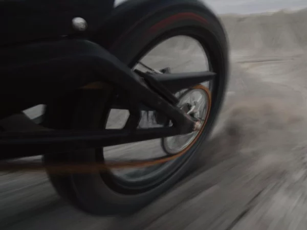 Das Hinterrad einer E Ride Pro in voller Fahrt beim beschleunigen auf losem Erd- oder Kies-Boden.